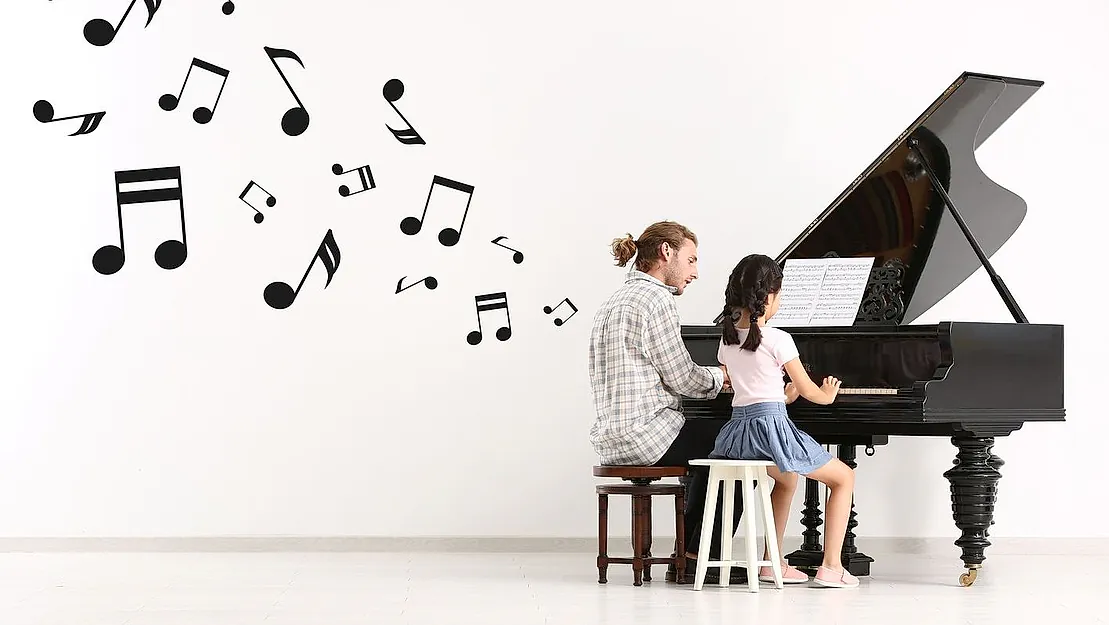 profesor tocando el piano con alumna